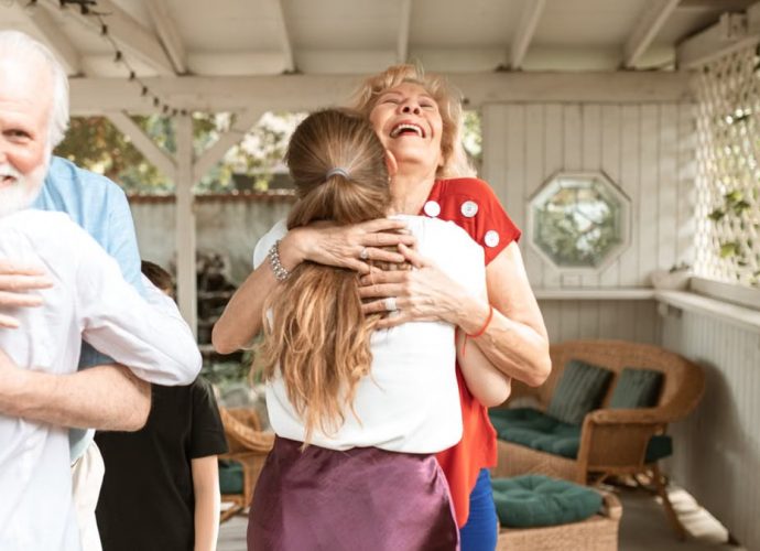 A heartwarming reunion with family members hugging and smiling in a cozy indoor setting.